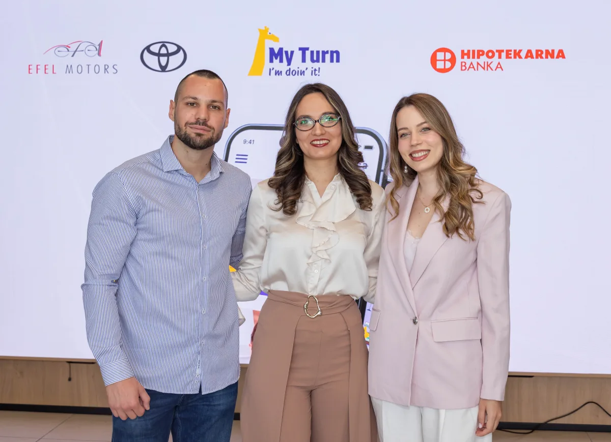 Članovi MyTurn tima ispred zida sa logotipima Efel Motorsa, Toyote, MyTurn-a i Hipotekarne banke